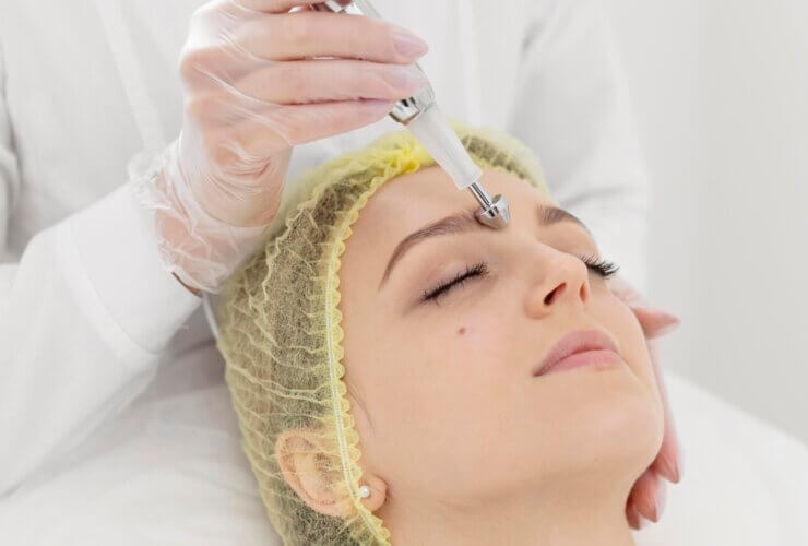 Woman receiving filler treatment at a beauty clinic, representing the rise in aesthetic procedures globally
