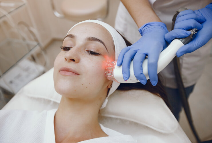 Professional using an aesthetic medical device on a woman at a cosmetology studio